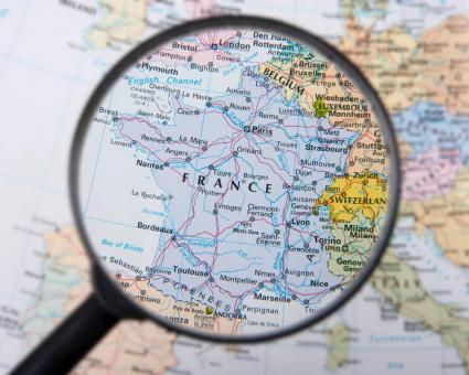 Photo d'une carte géographique avec une loupe sur la France 